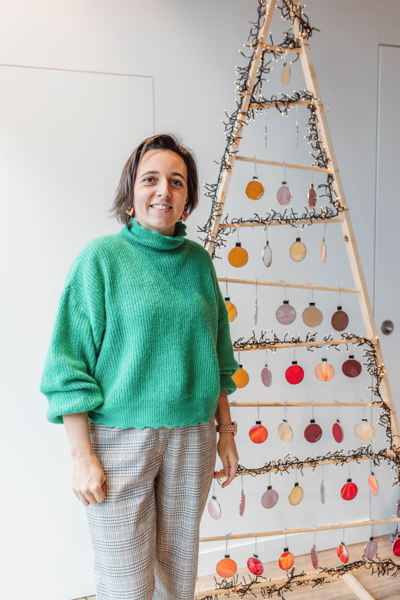 Nina poseert voor haar glaswerk kerstboom