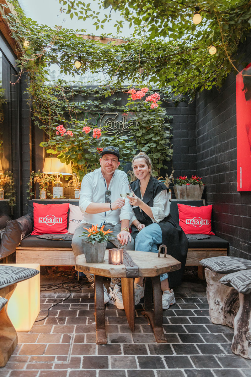 Kurt en partner zitten samen op het terras en klinken erop.