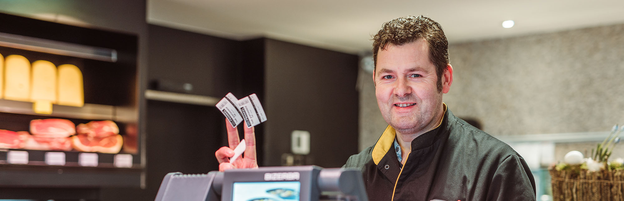 Ondernemer aan zijn weegschaal met kleefticketten in zijn hand