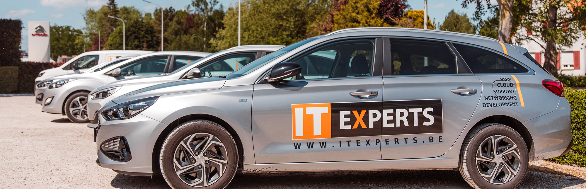 Eén van de IT experts bedrijfswagens. Grijze wagen met het logo erop.