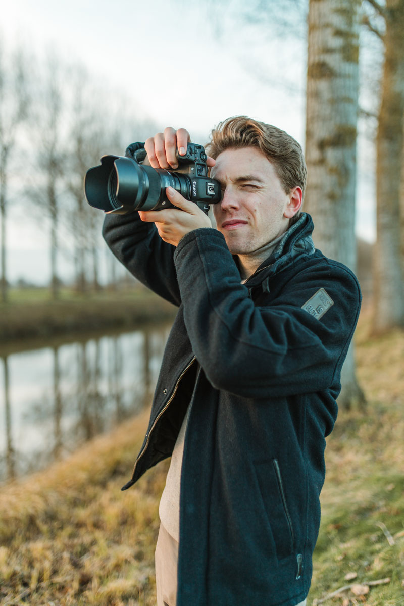 Portret van Gerben terwijl hij buiten aan het fotograferen is aan een kanaal.