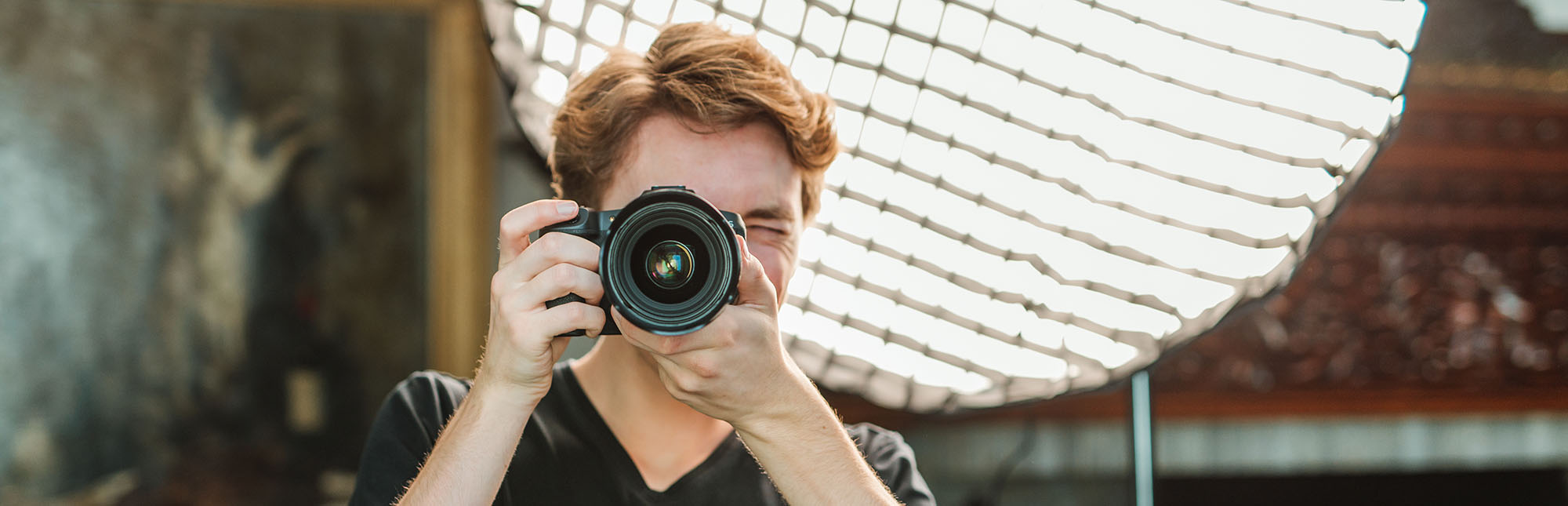 Portret van Gerben terwijl hij door zijn camera kijkt.