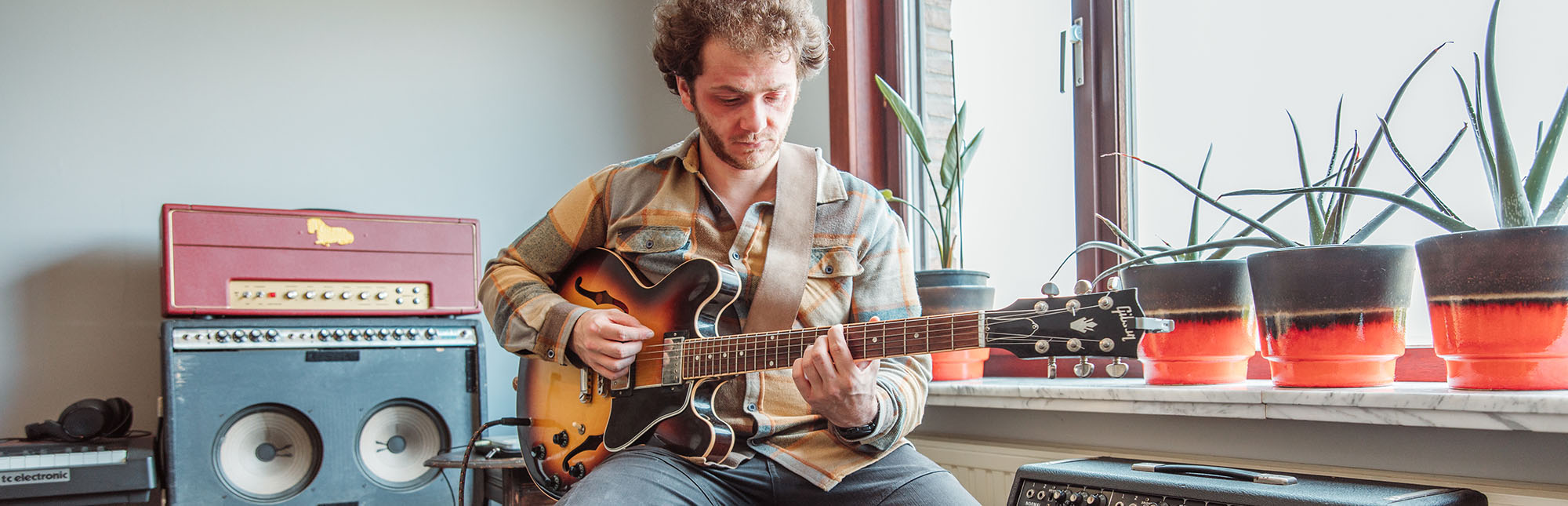 Alexander speelt op zijn gitaar.