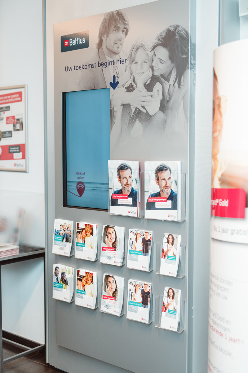 Zuil met een digitaal bord en flyers errond.