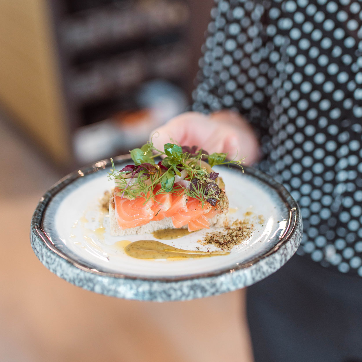 Prachtig gedresseerd bord met rauwe zalm en salade.