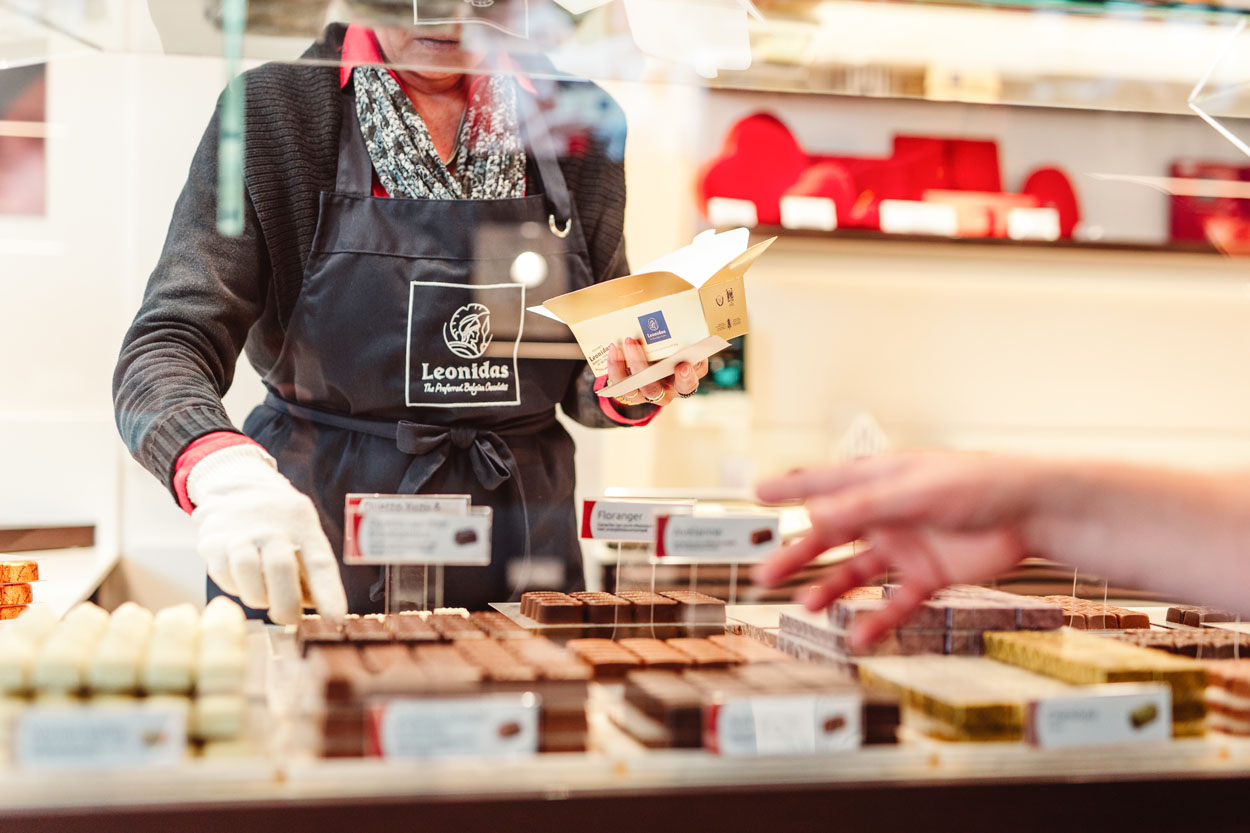 Close up: Pralines worden gekozen door de klant en in een doosje gestoken.