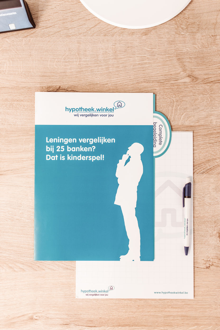 Een flyer op een tafel met daarop: Leningen vergelijken bij 25 banken? Dat is kinderspel.