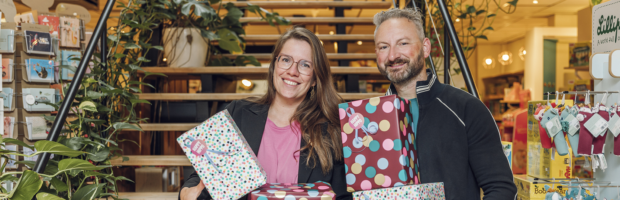 Portret van Sven en Jo, Zaakvoerders van Happy Hippo. In hun handen cadeautjes.